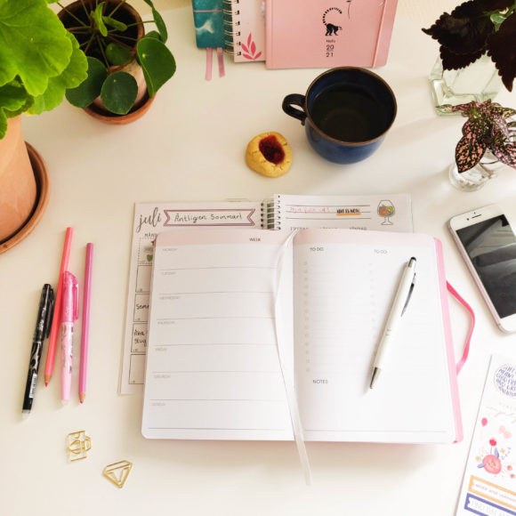 Week Planner rosa på ett bord